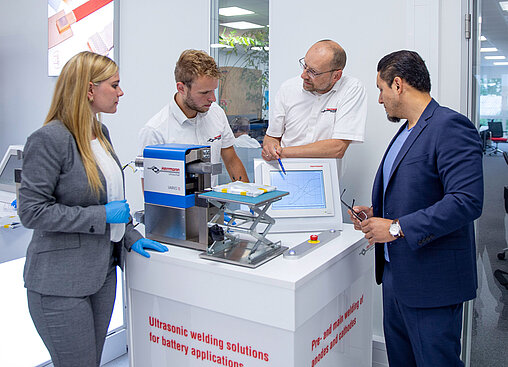 Colleagues and customers conduct joint trials to optimize the welding process for a battery