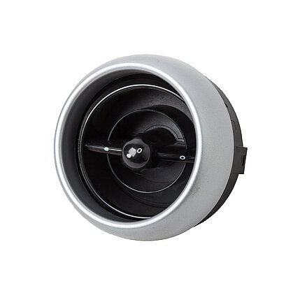 Round black vehicle air vent with a silver frame